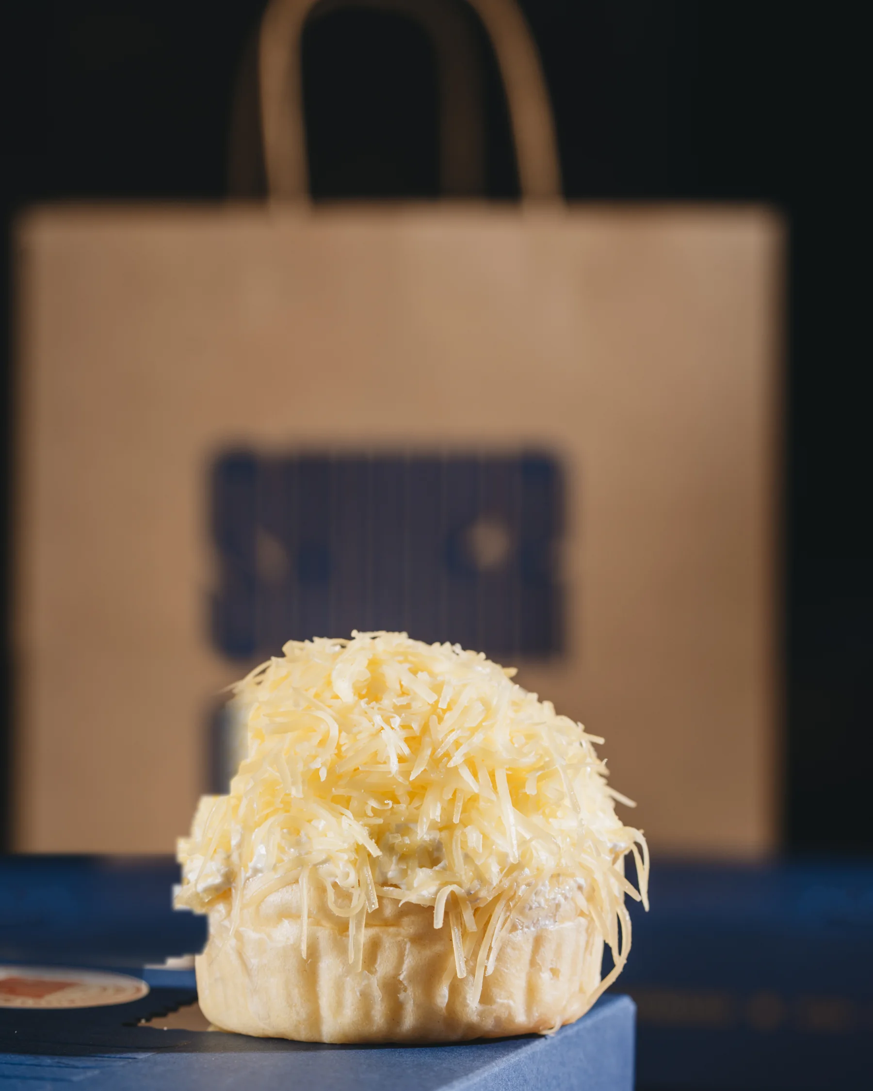 The kraft carry bag, a single ensaymada set in front of it